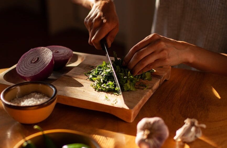 a woman chopping cilantro