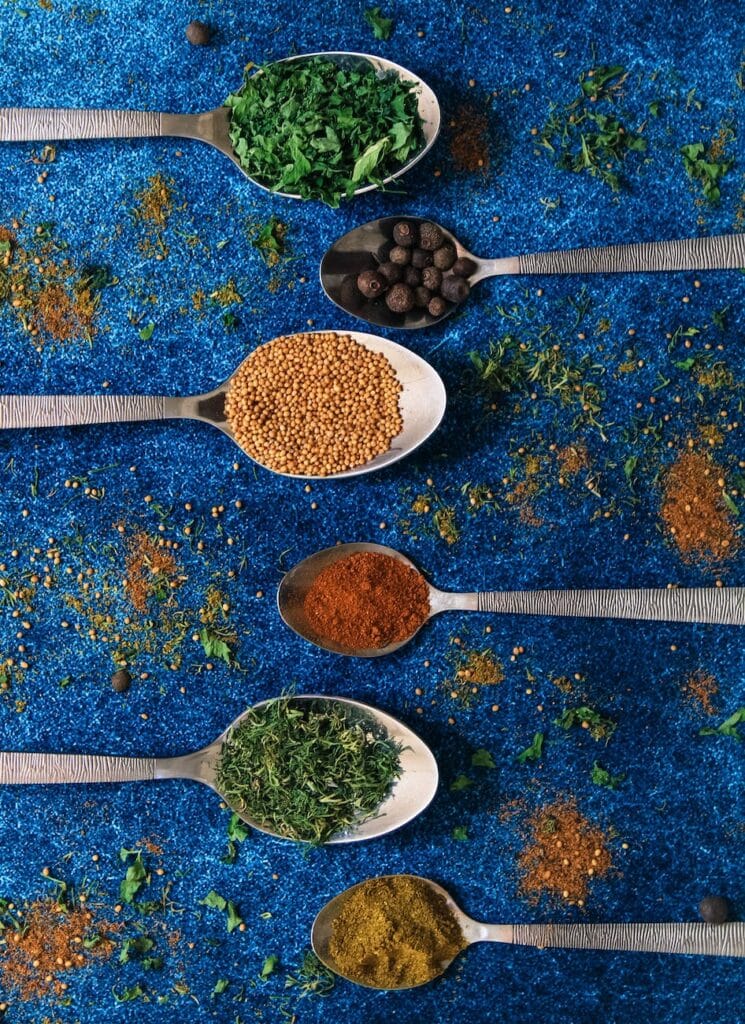 variety of spices on spoons found in Belizean Ingredients