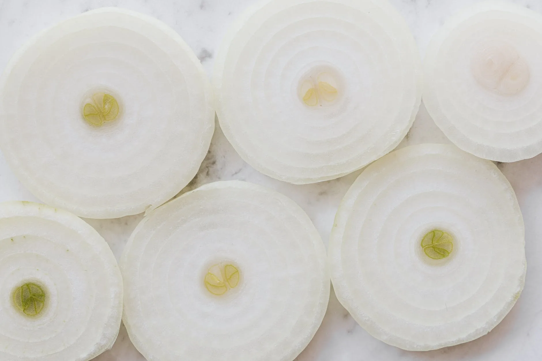 raw onion rings on marble surface