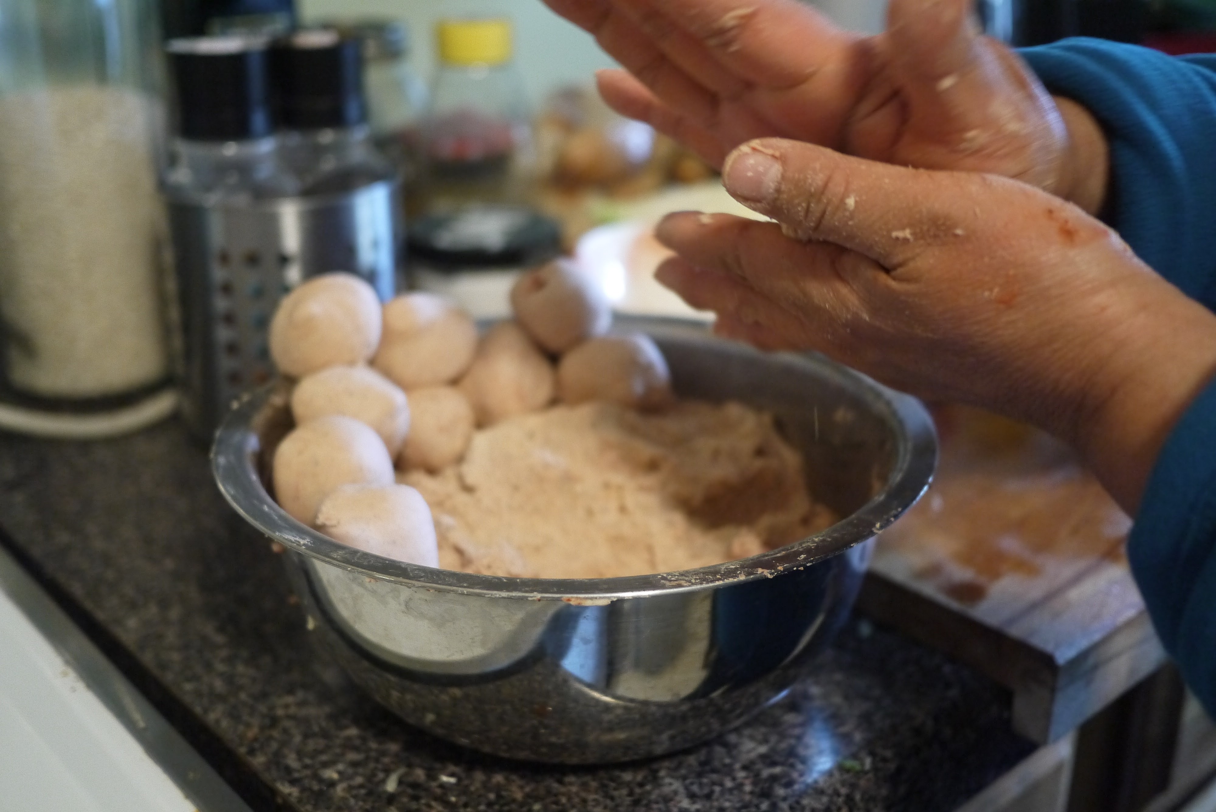 close up forming masa ball for corn tortilla between palms
