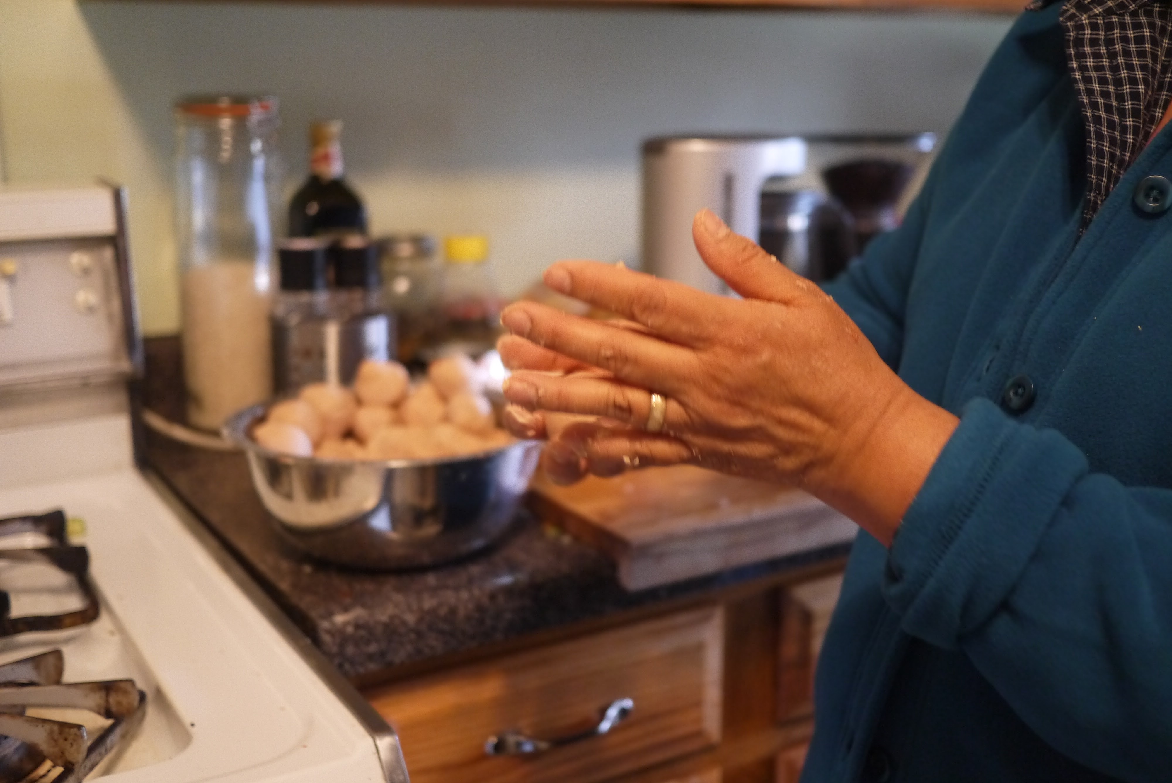 moistening hands before forming masa balls for Belizean corn tortillas