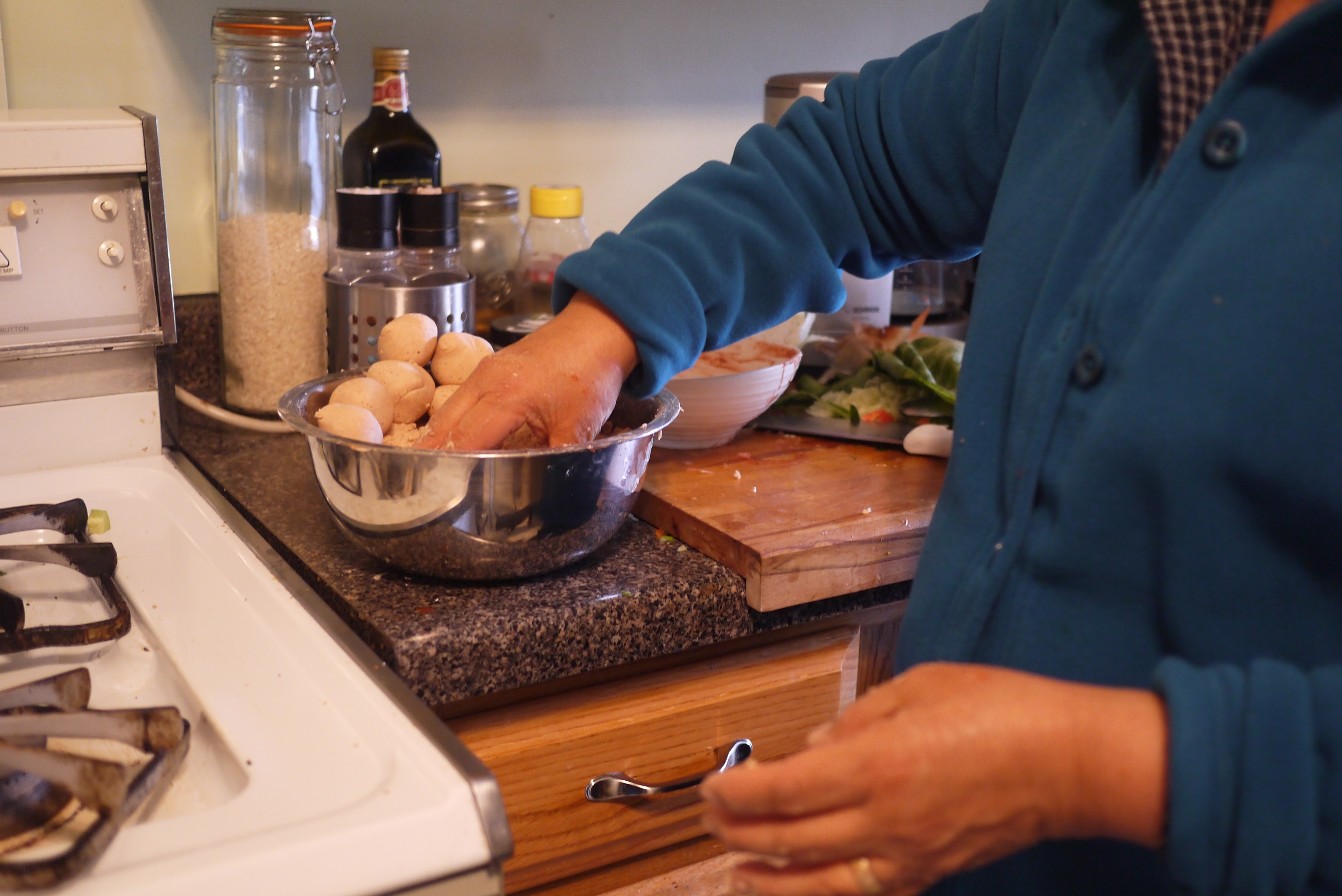 taking a portion of masa from bowl to form corn tortilla dough ball by hand