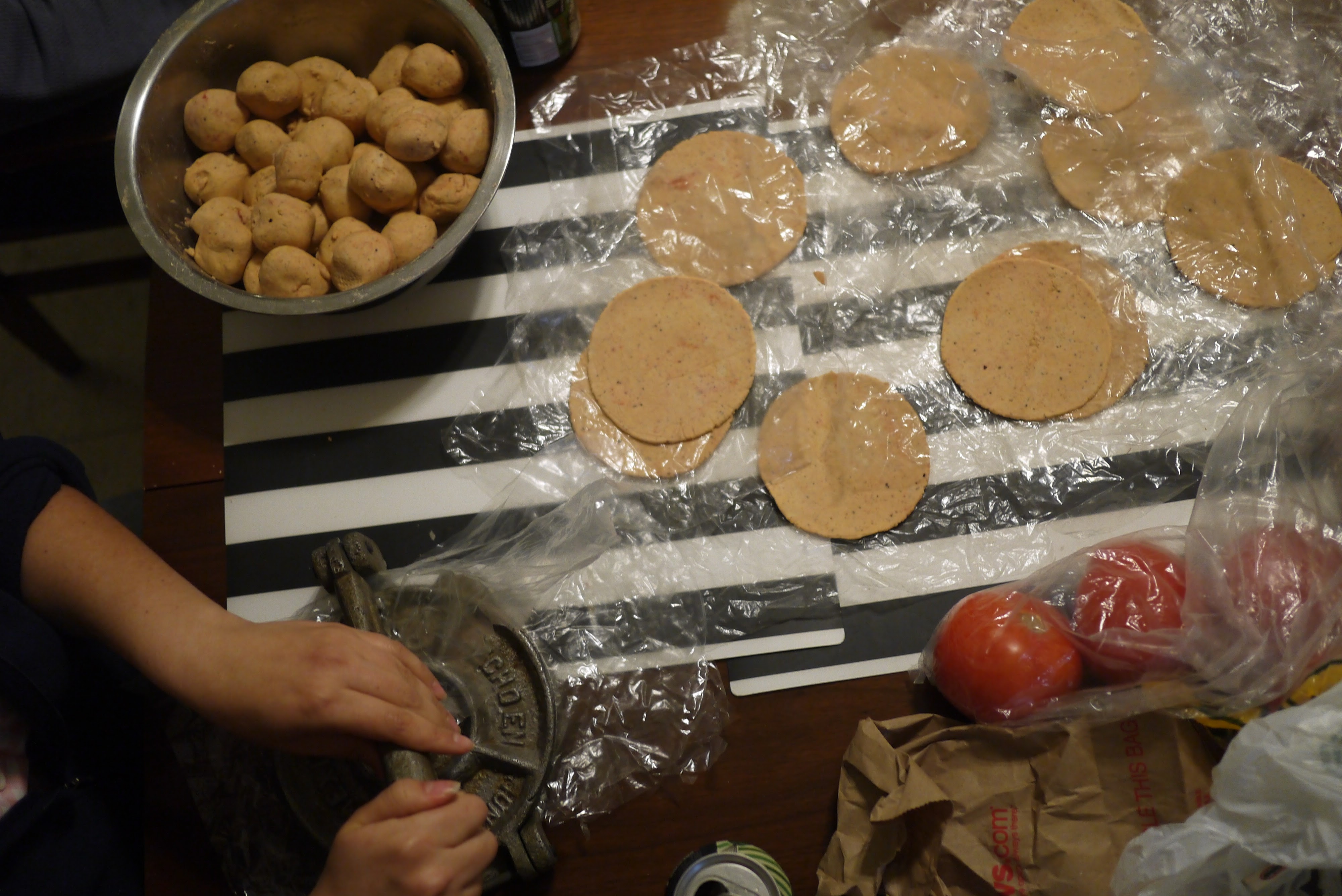 pressing masa ball in cast iron tortilla press for Belizean corn tortillas