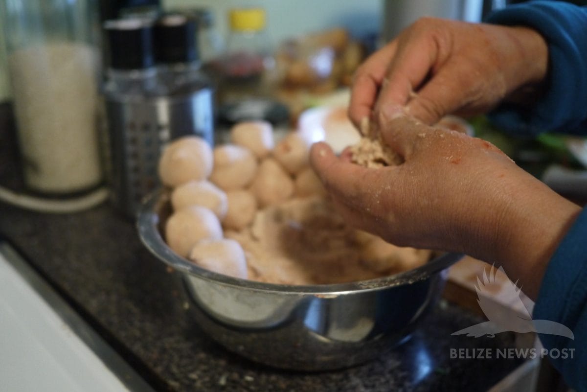 Hands pressing thumb into masa ball to form the canastilla shape for joroches