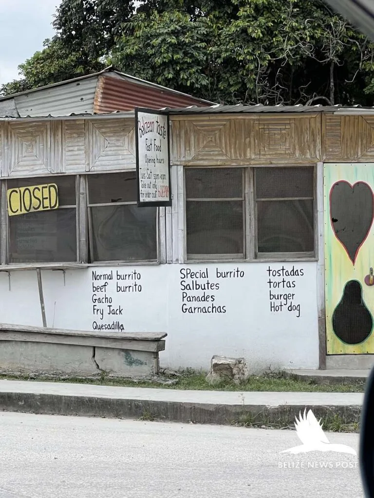 Belizean roadside food vendor with painted menu listing salbutes, panades and garnachas — orange walk tacos belize news post