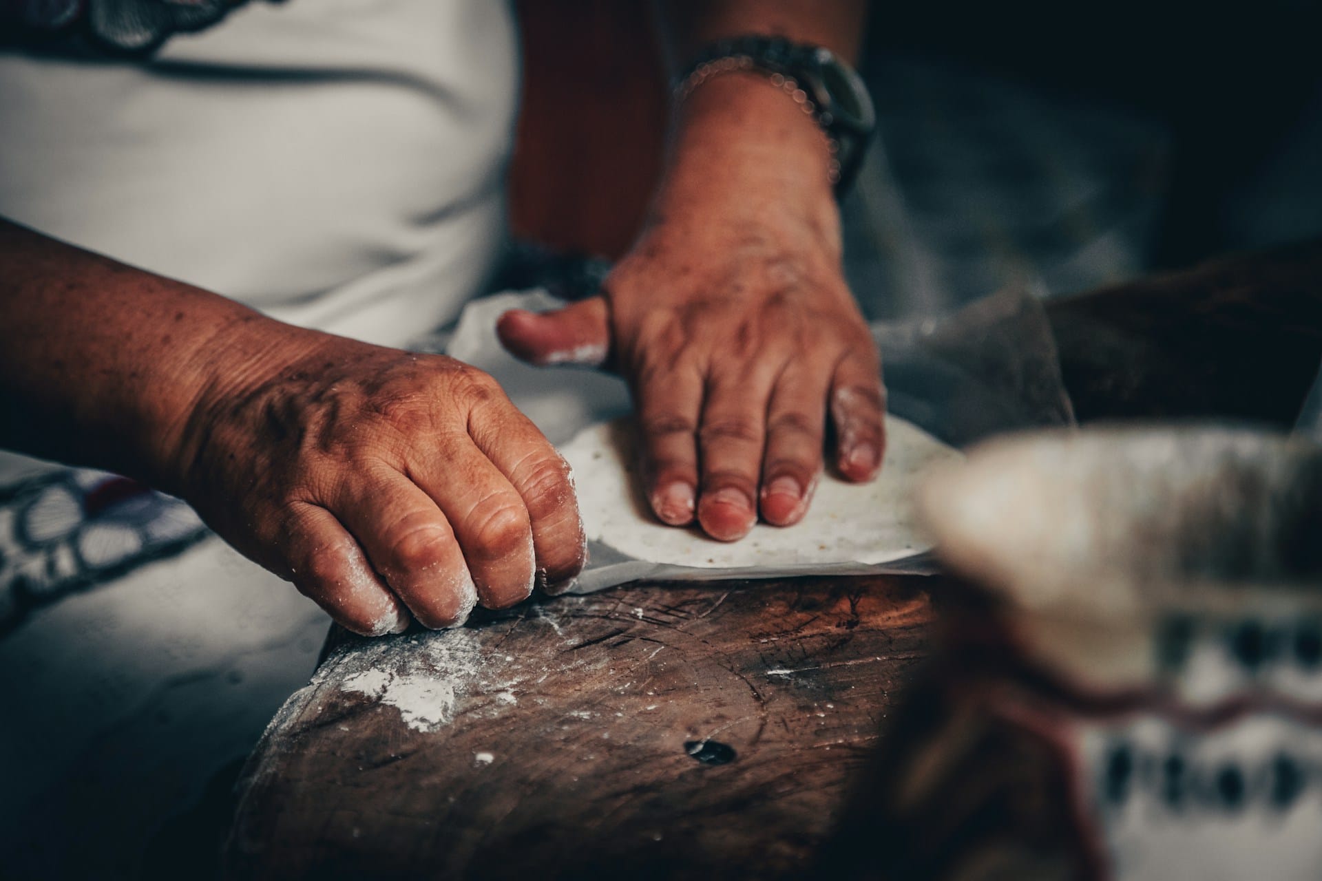homemade corn tortilla cooking on a comal — the surface blisters and puffs as the pocket forms inside the panuchos tortilla