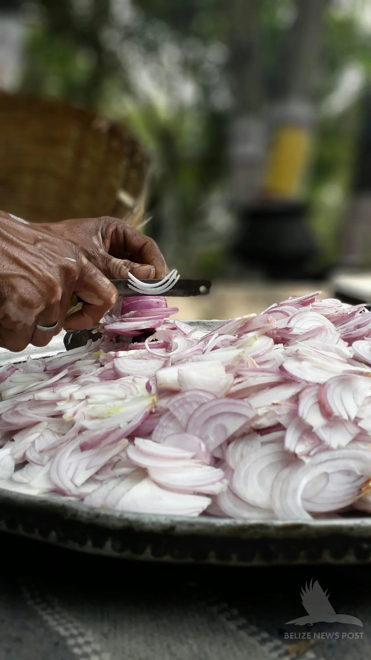 hands slicing red onion for salpicon — the topping for polcanes yucatecos, served like a tostada