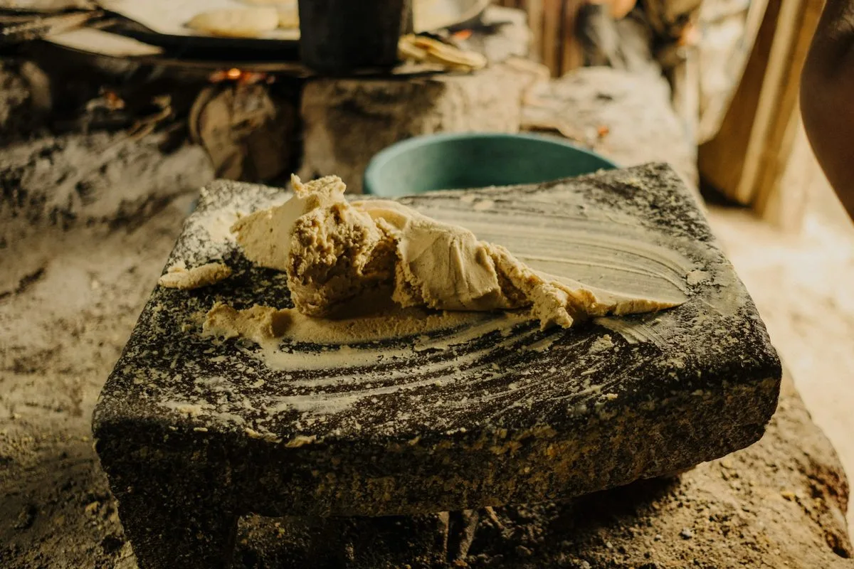 Fresh corn masa ground on a stone metate in a Guatemalan kitchen