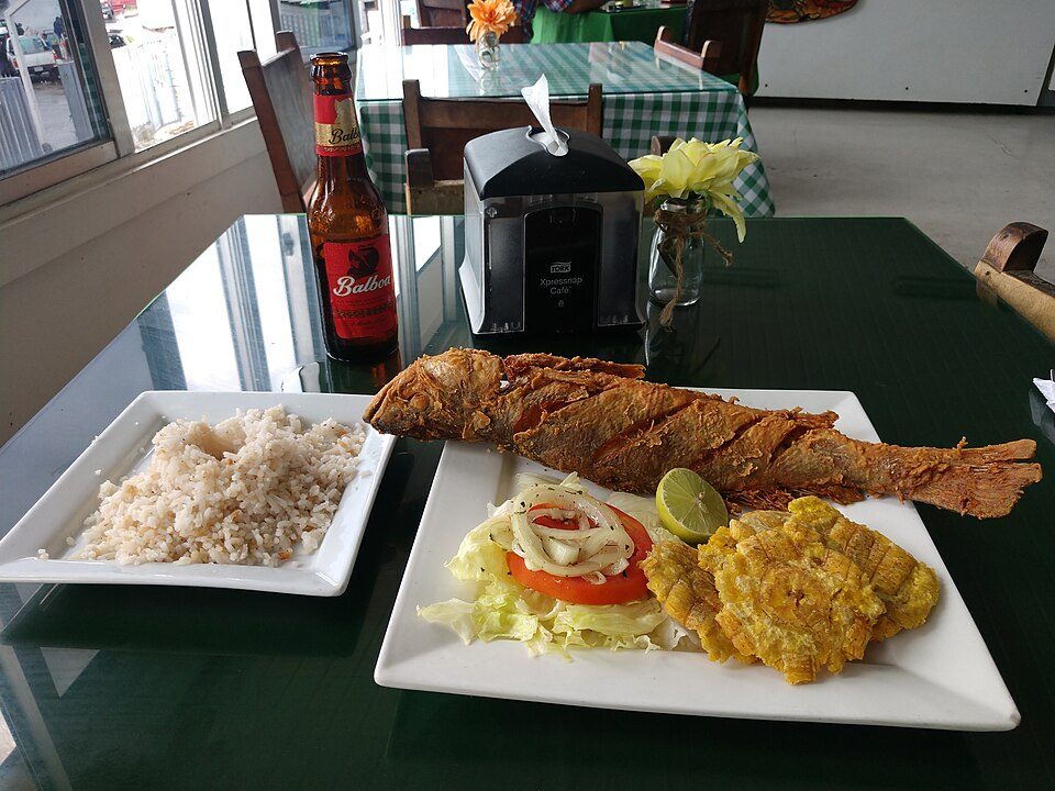 Whole fried fish with coconut rice and patacones, Caribbean-coast style