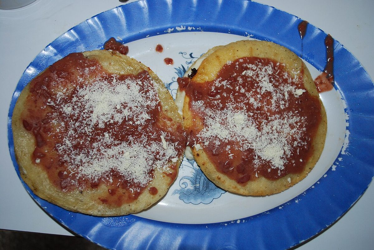 Tortillas topped with Honduran quesillo cheese and tomato sauce