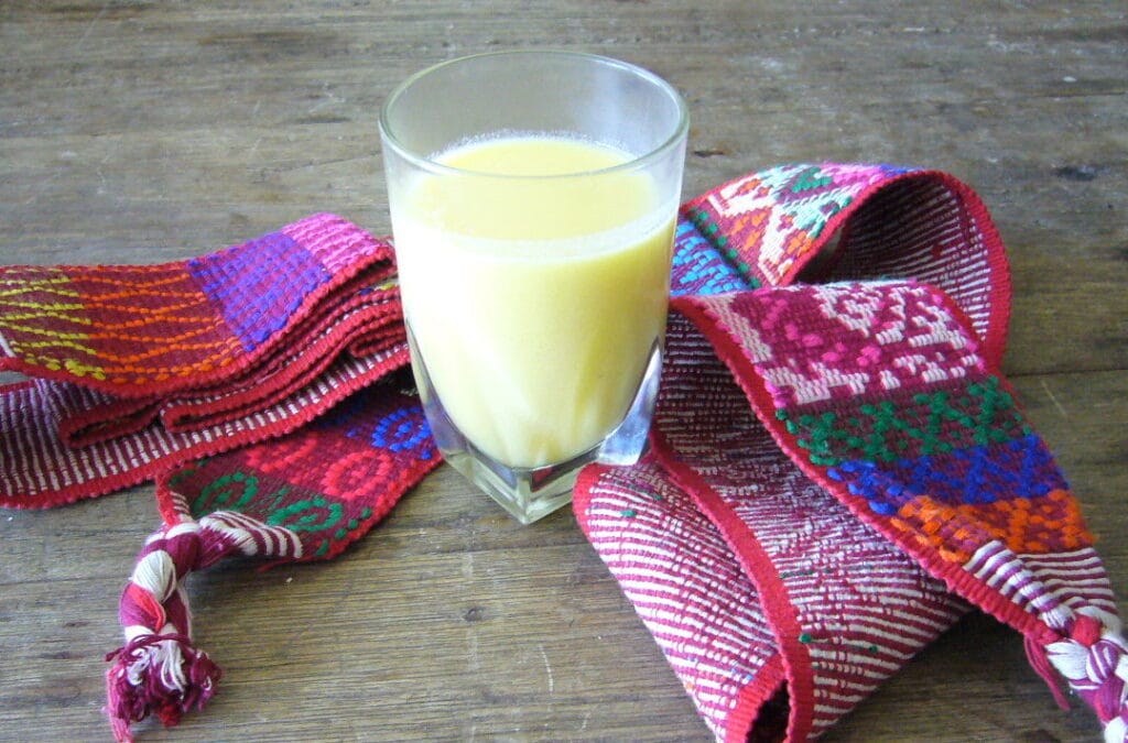 Atol de elote, a warm Honduran sweet corn drink, served in a mug with cinnamon