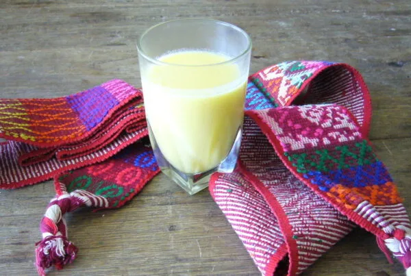 Atol de elote, a warm Honduran sweet corn drink, served in a mug with cinnamon