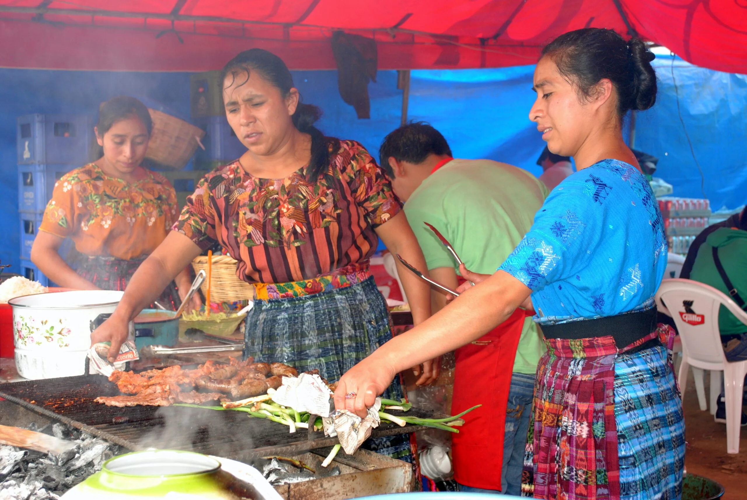 Indigenous Guatemalan Maya women in traditional dress preparing typical highland food