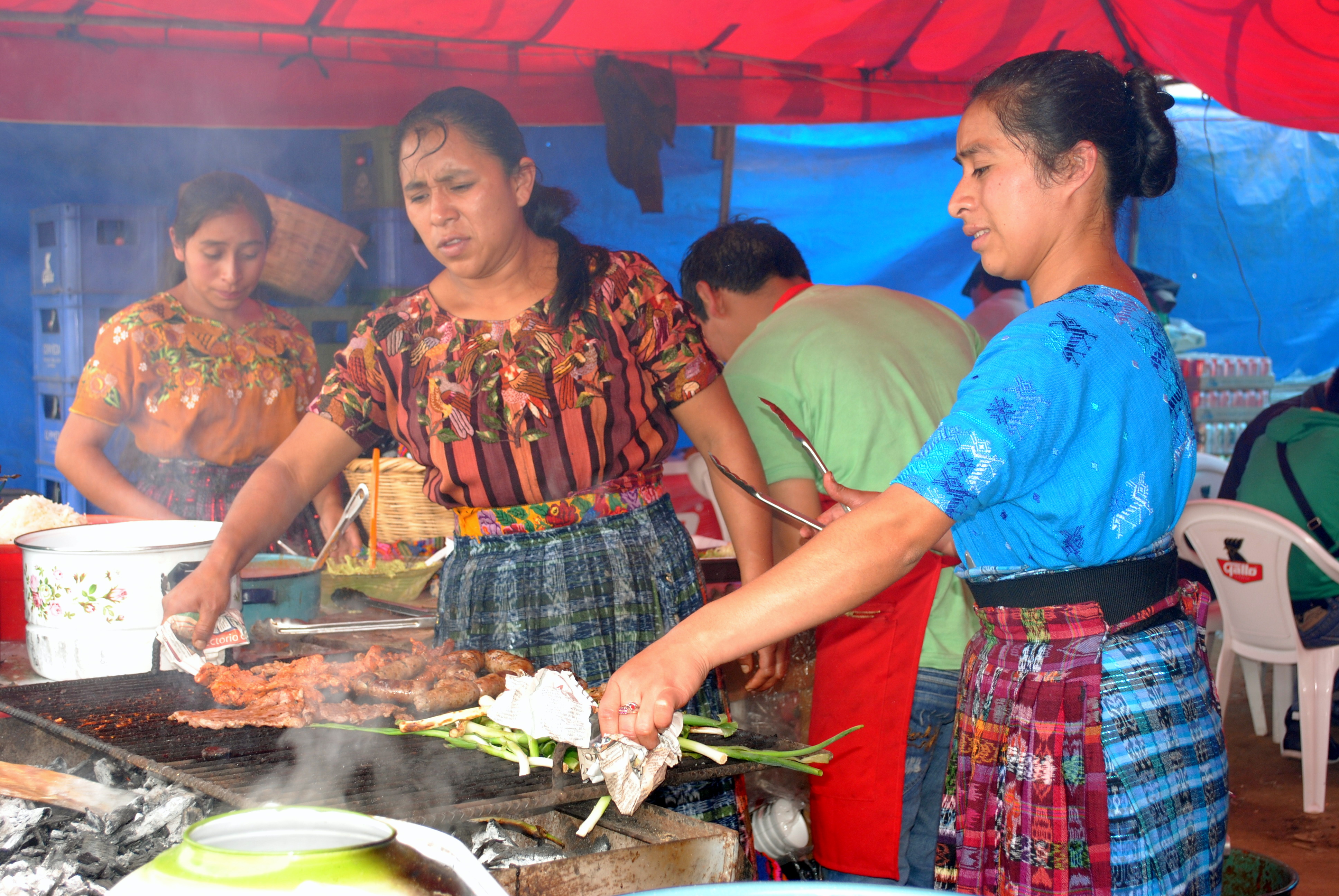 Indigenous Guatemalan Maya women in traditional dress preparing typical highland food