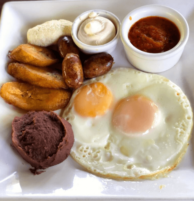 Salvadoran breakfast plate with plátanos fritos, frijoles molidos, crema, and queso