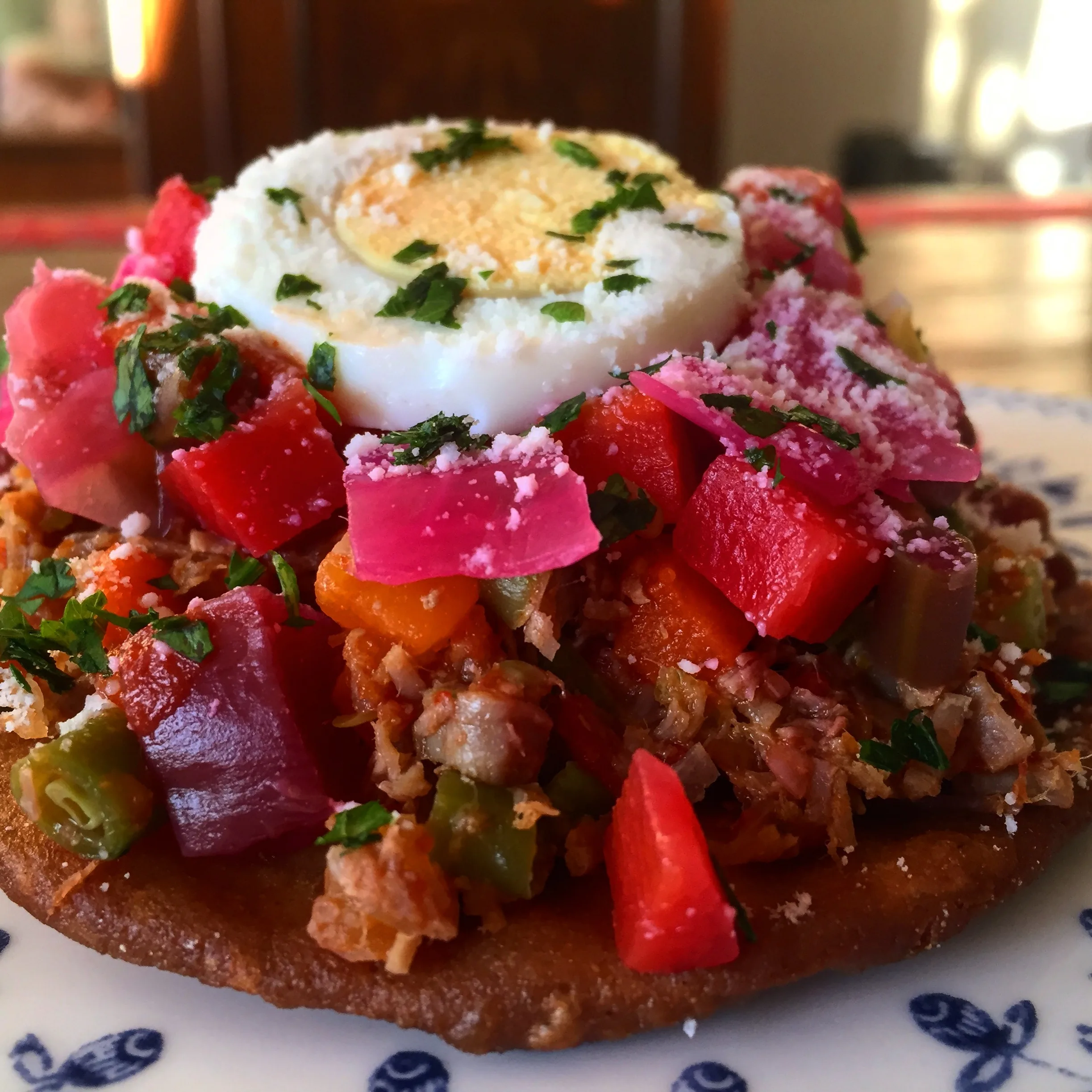 Guatemalan enchilada: an open-faced tostada topped with beef, purple beet curtido, hard-boiled egg, and dry cheese