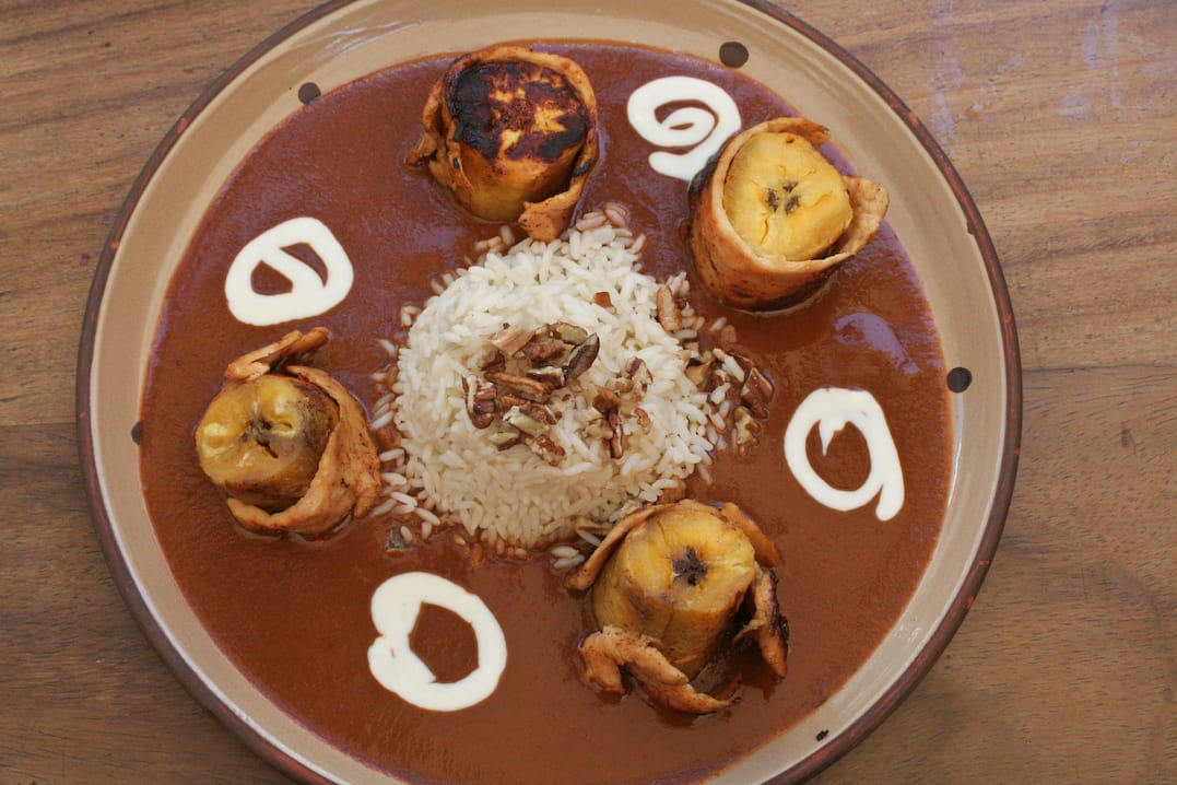 Dark chocolate mole sauce with fried plantains — traditional Guatemalan mole de platano