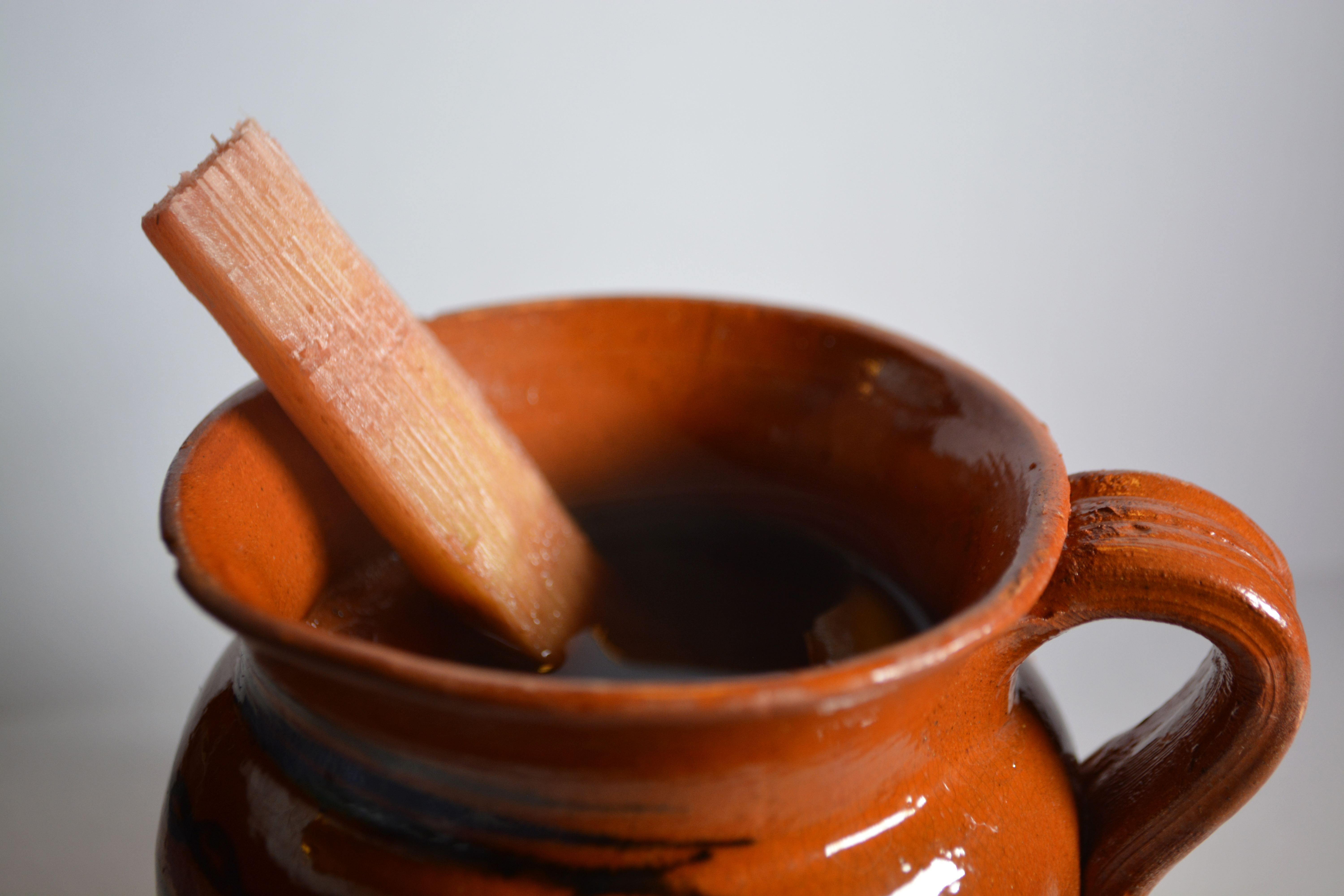 Steaming cup of ponche guatemalteco, hot Guatemalan Christmas fruit punch with cinnamon sticks and dried fruits