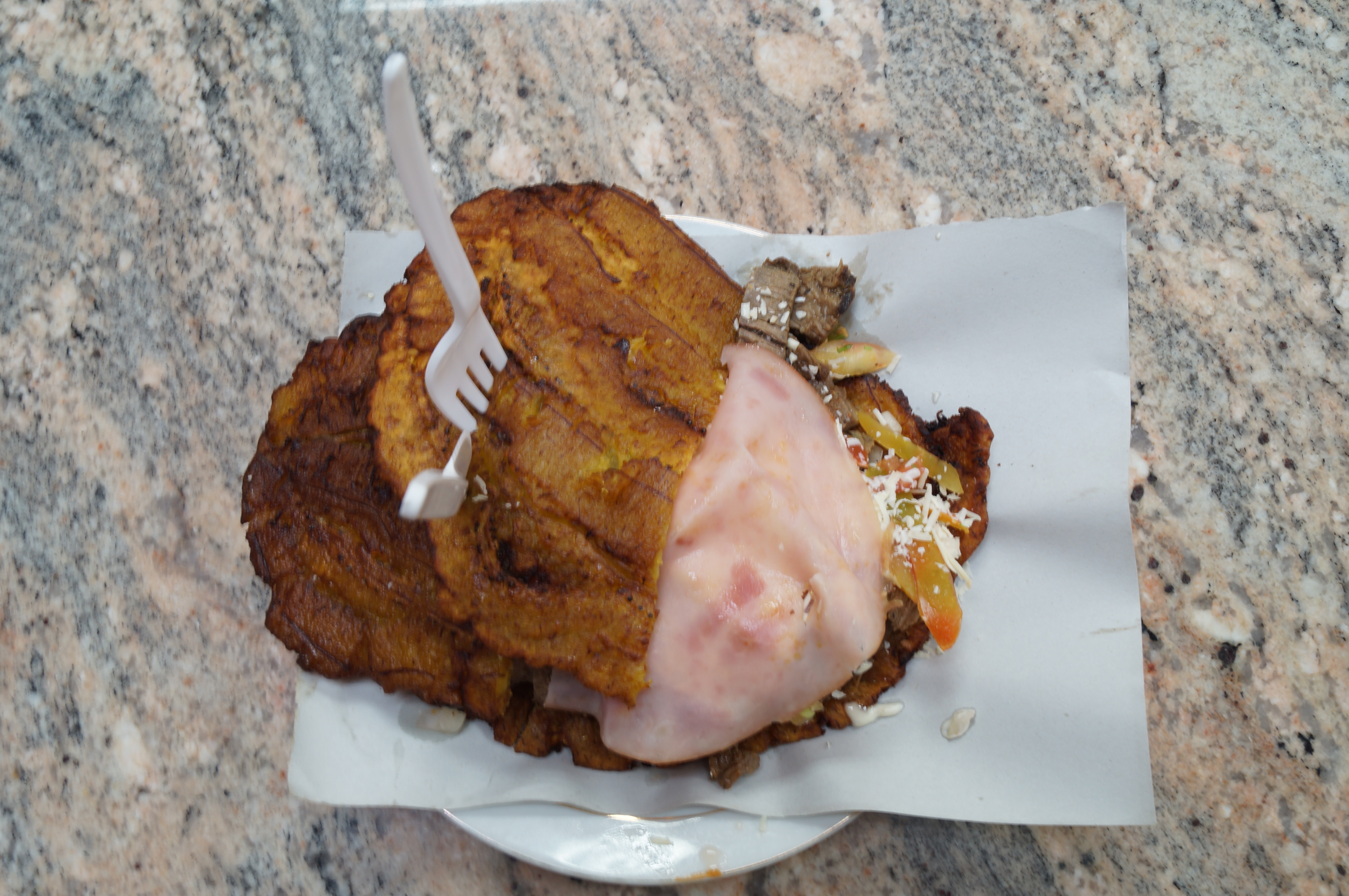 Ripe plantains being mashed for plantain dough, showing the yellow skin with black spots that indicates proper ripeness for empanadas de platano