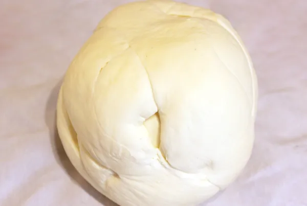 A ball of fresh white quesillo, the soft stretched melting cheese used in Honduran baleadas