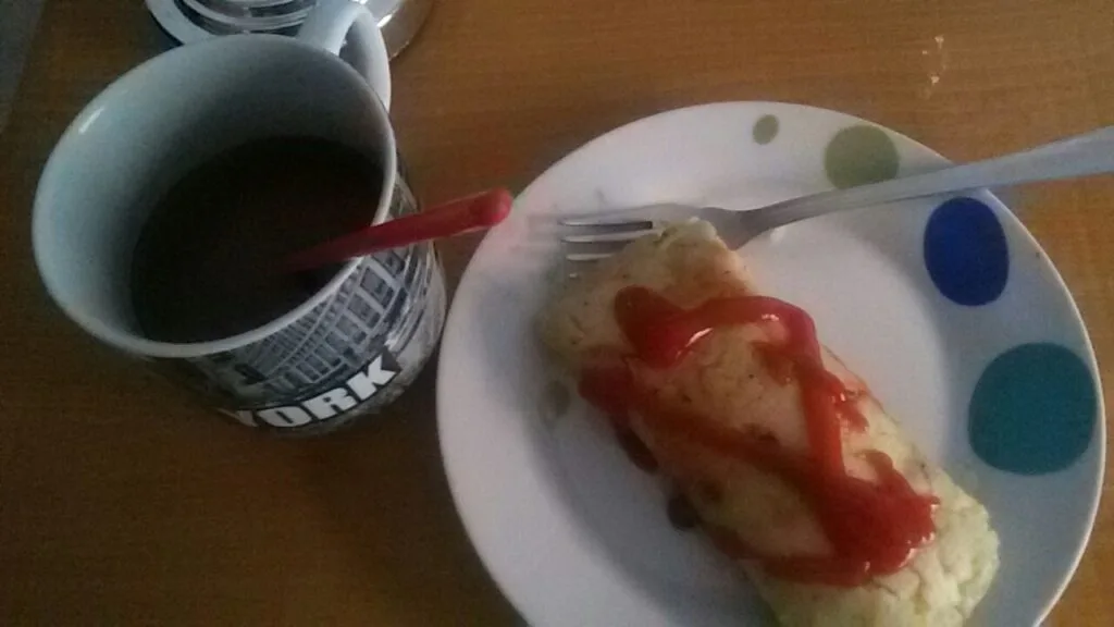 A Honduran tamale wrapped in corn husk served with a cup of coffee