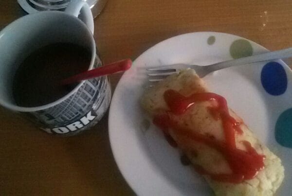 A Honduran tamale wrapped in corn husk served with a cup of coffee