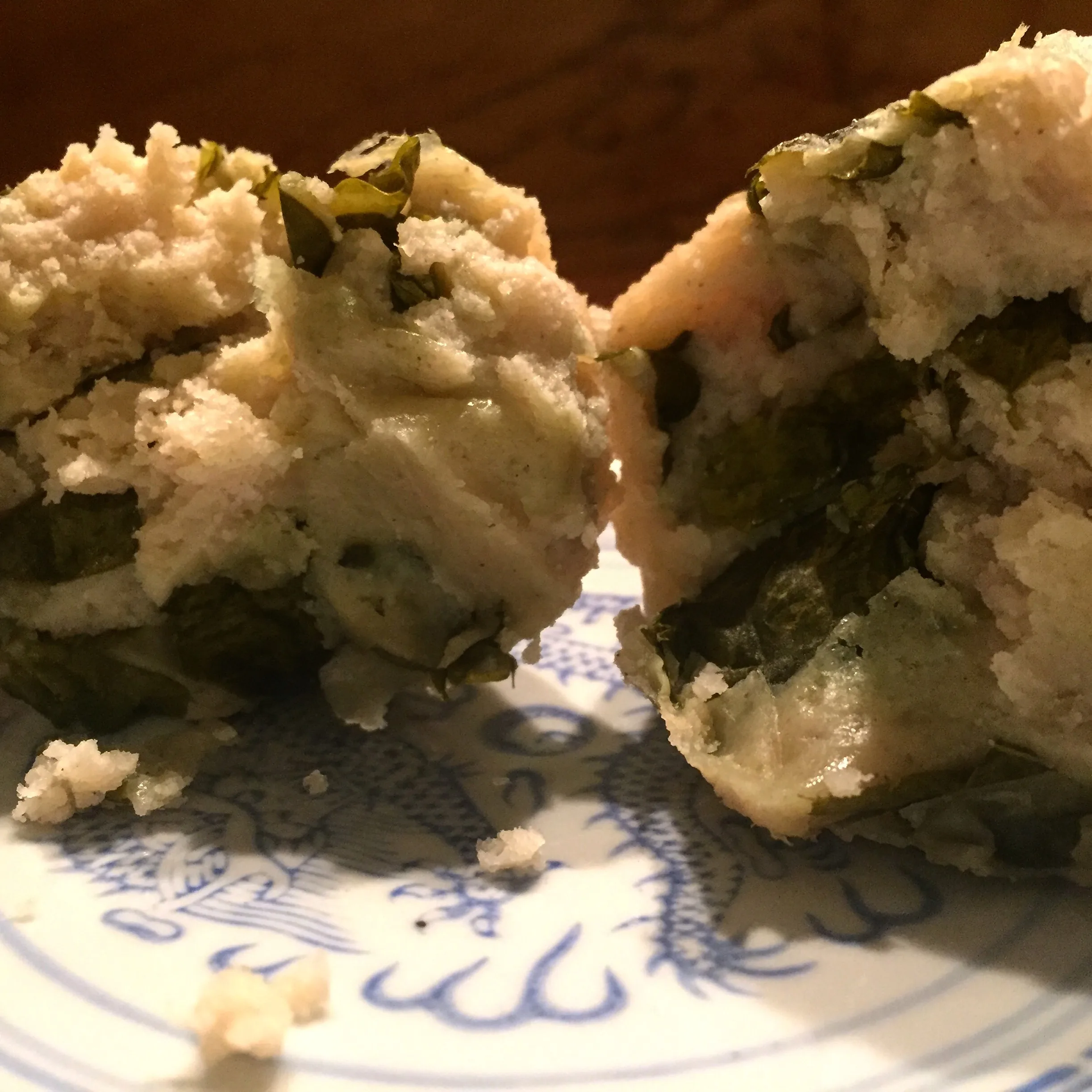 Boxboles — Q'eqchi' Maya corn masa rolls with chipilín, served with toasted pepita sauce and crumbled white cheese