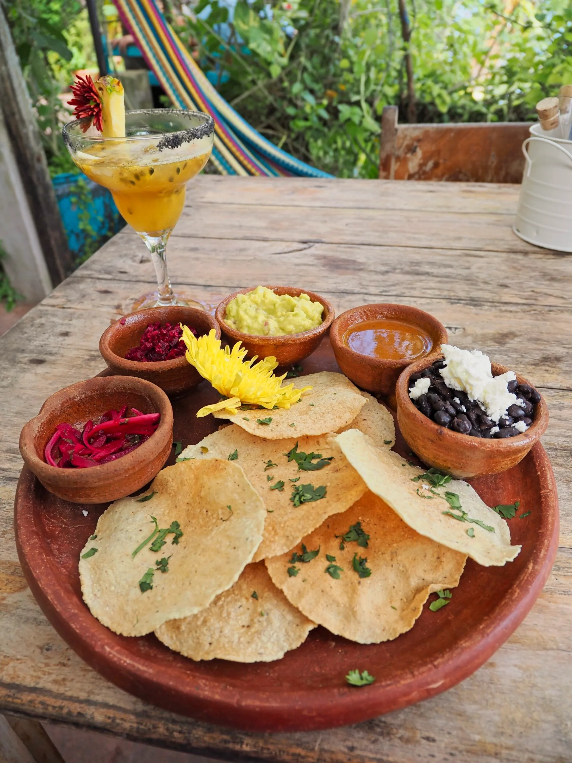 Three Guatemalan tostadas topped with refried beans, guacamol, and tomato salsa, finished with onion, parsley, and grated queso seco