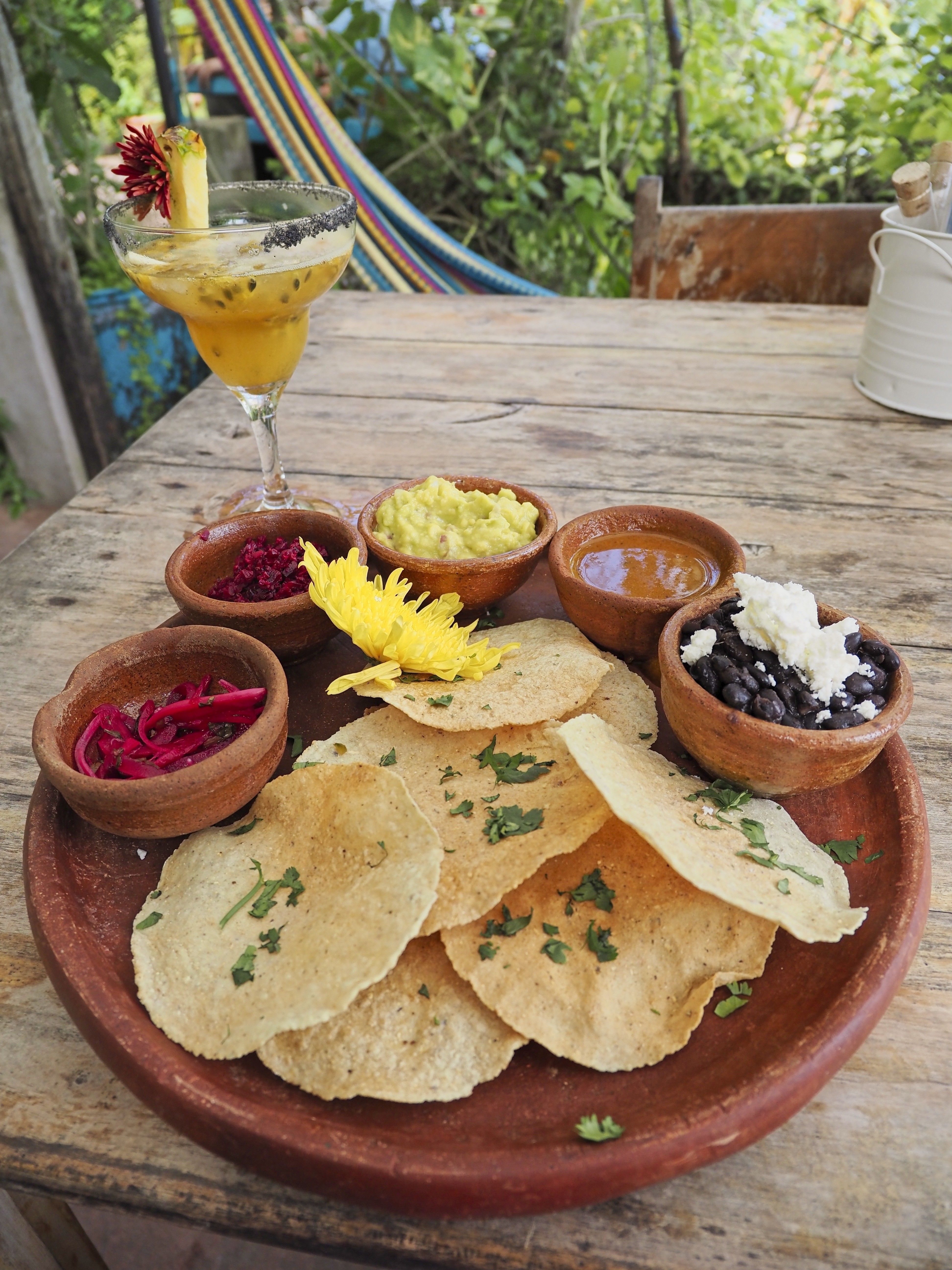 Three Guatemalan tostadas topped with refried beans, guacamol, and tomato salsa, finished with onion, parsley, and grated queso seco