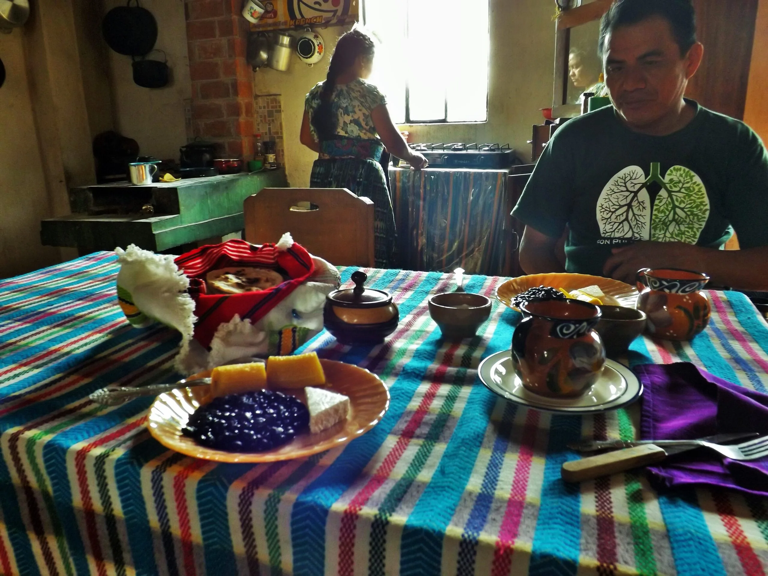 Traditional Guatemalan breakfast plate with frijoles volteados, fried eggs, plantains, tortillas, and crema - San Juan la Laguna, Guatemala