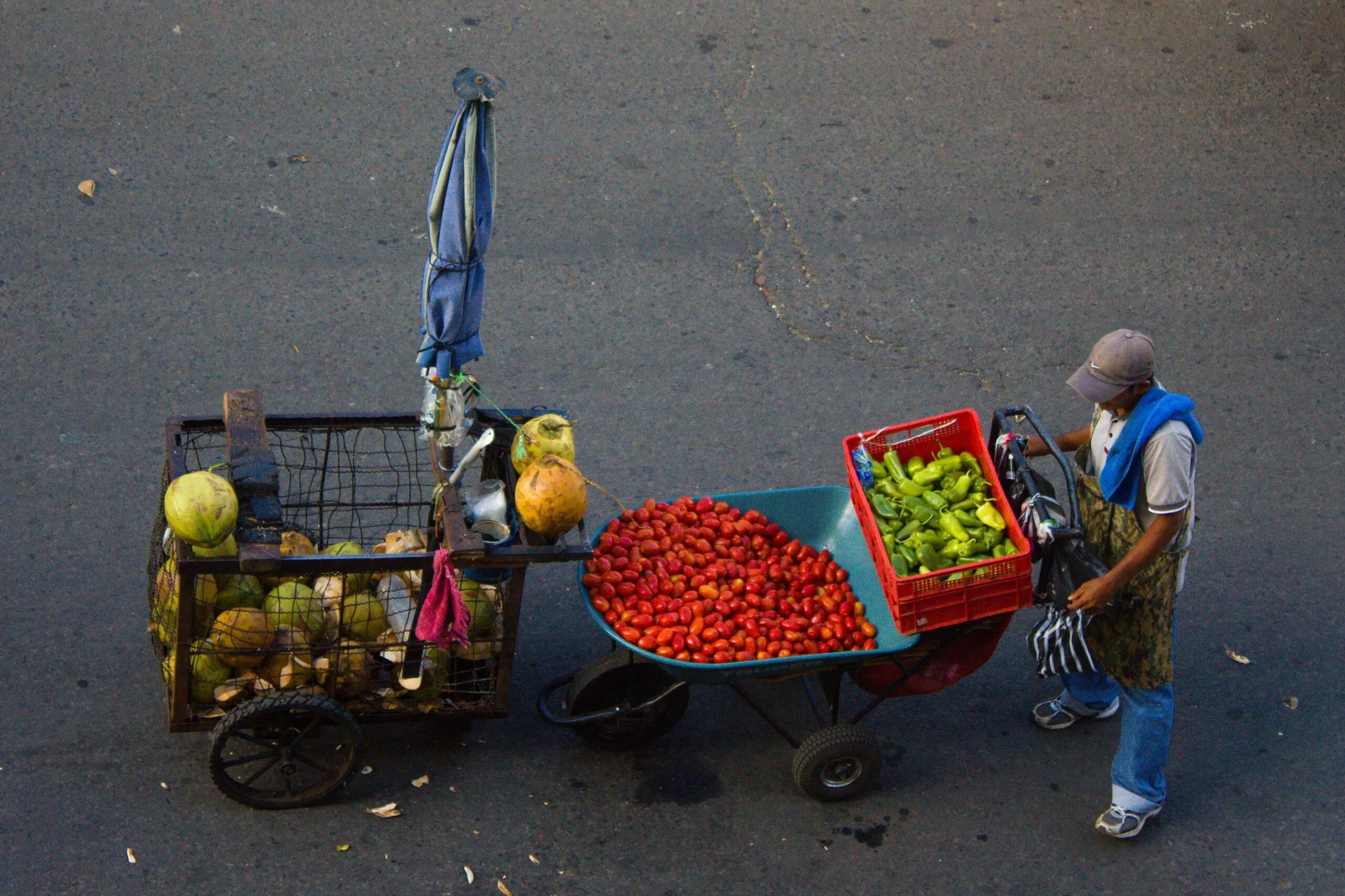 A street vendor selling produce in San Salvador, El Salvador — the kind of market stall where riguas are often sold freshly griddled