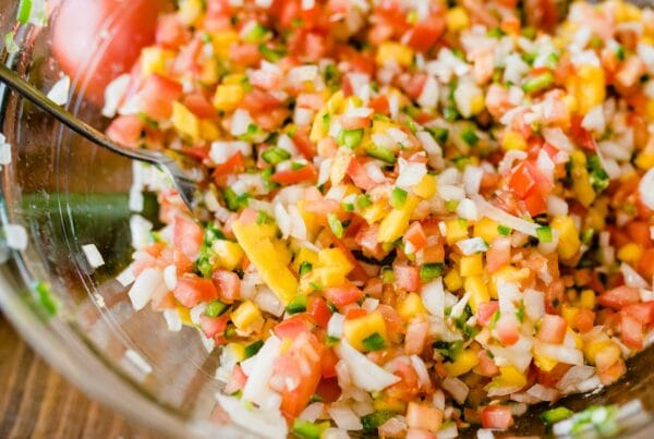 Glass bowl of Honduran chismol with finely chopped tomato, onion, green bell pepper and cilantro