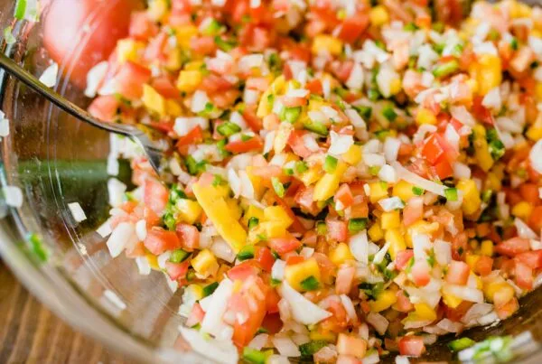 Glass bowl of Honduran chismol with finely chopped tomato, onion, green bell pepper and cilantro