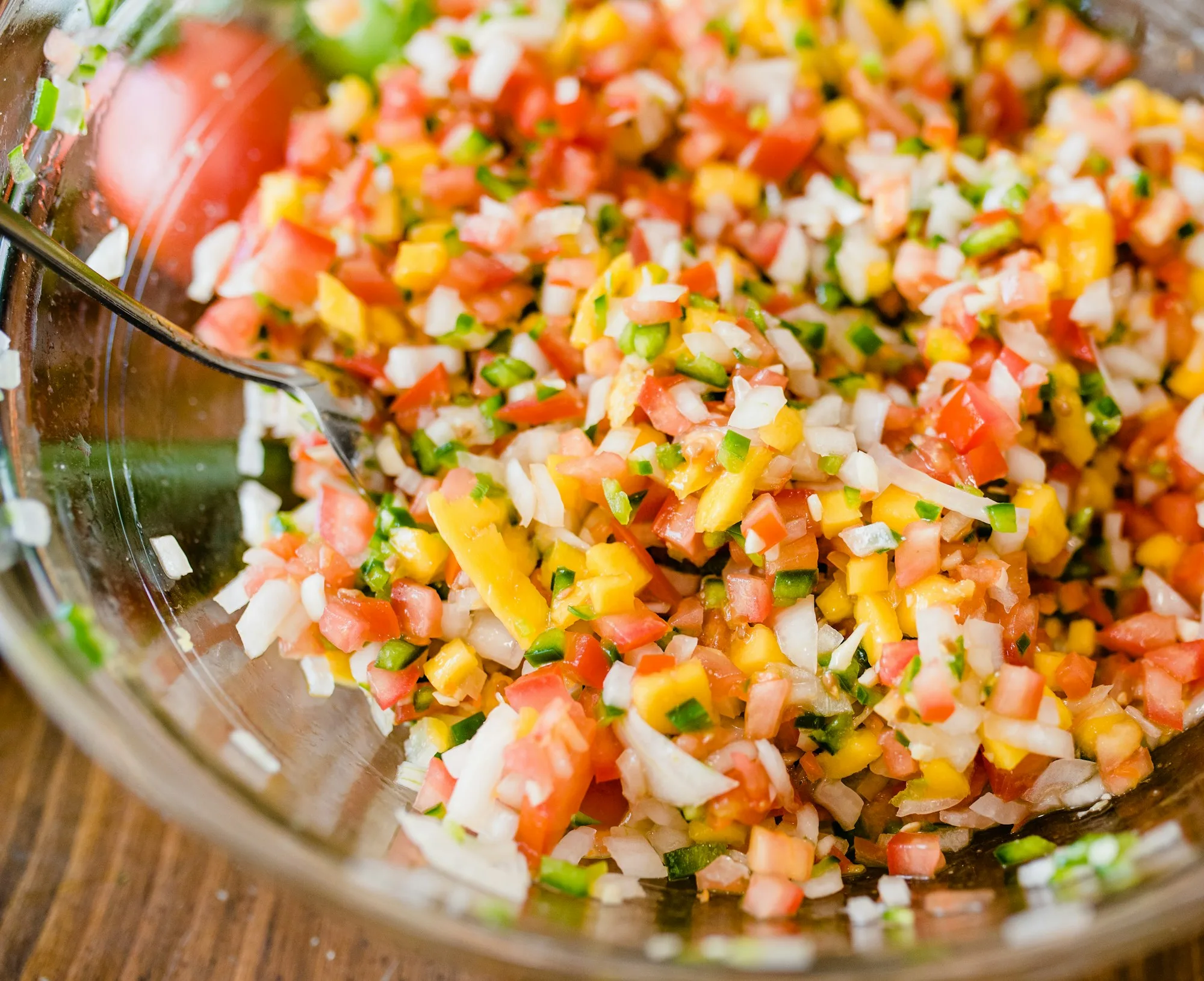 Glass bowl of Honduran chismol with finely chopped tomato, onion, green bell pepper and cilantro