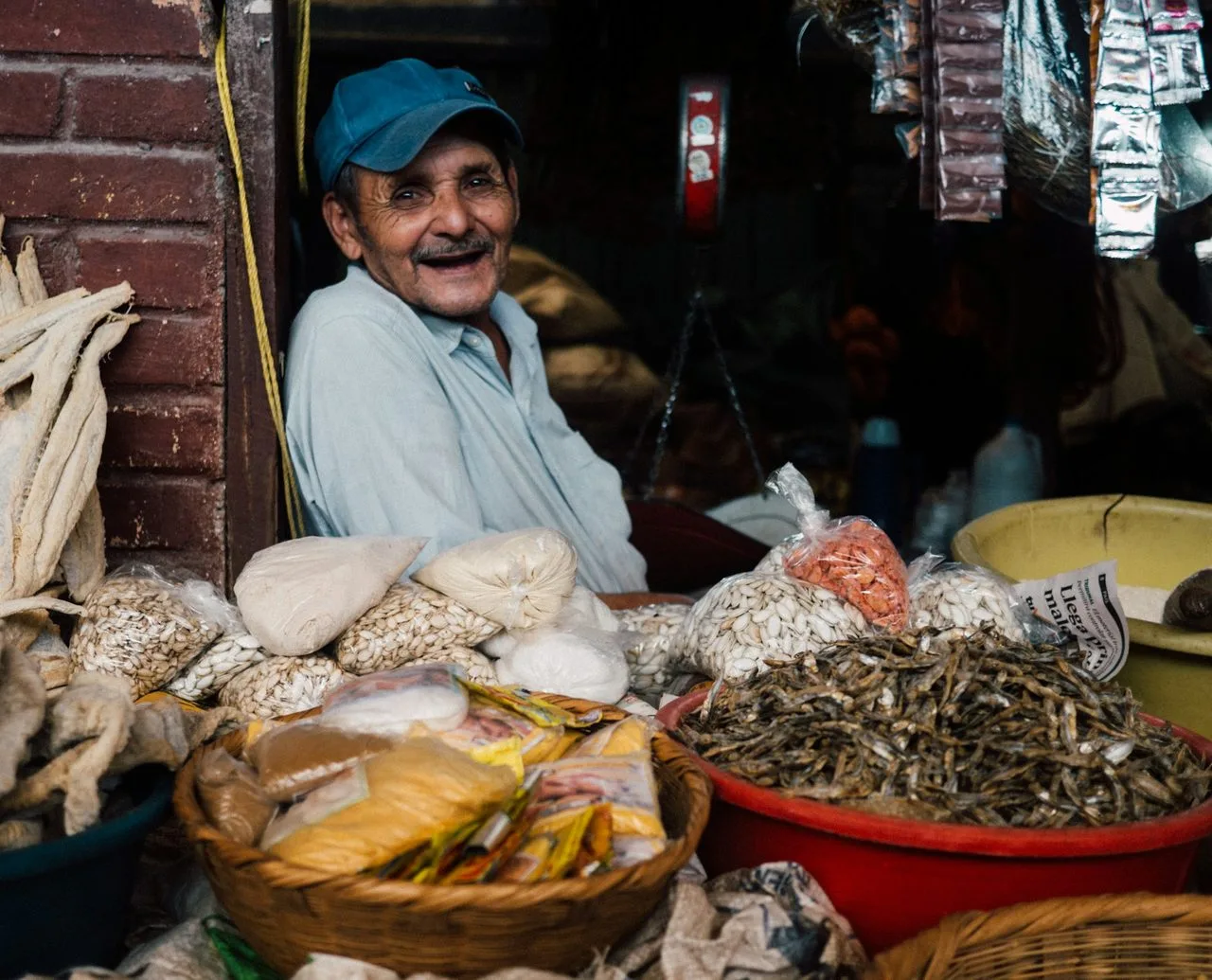 Market vendor in Copán, Honduras selling dried red beans, grains, and seeds