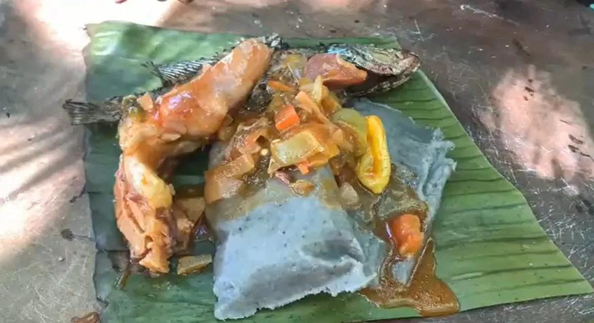 Darasa green banana tamale on a banana leaf with fried fish