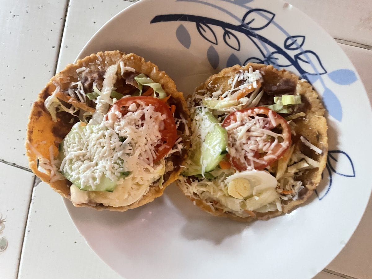 Enchiladas salvadoreñas, flat crisp tortillas with curtido, cheese, and egg