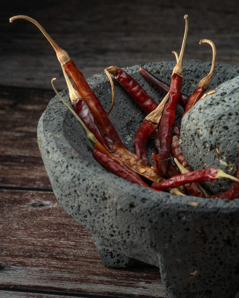 Dried red chiles in a stone molcajete, the recado base for hilachas