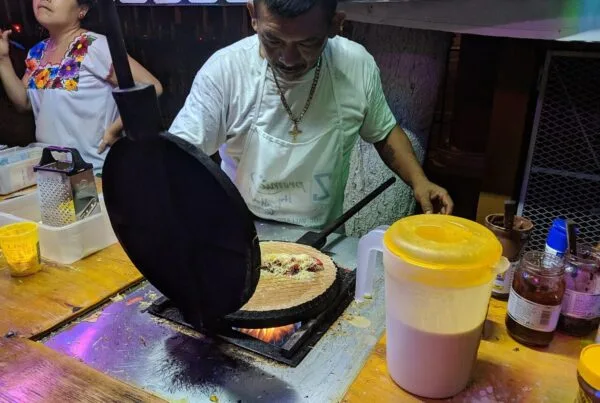 A vendor pressing a marquesita on the round iron in Merida