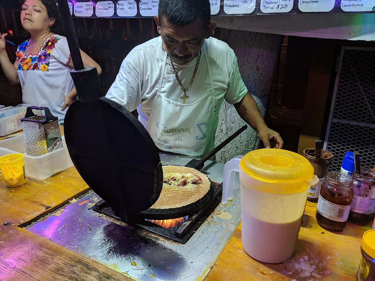 A vendor pressing a marquesita on the round iron in Merida