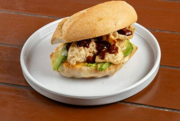 A Salvadoran chicken sandwich (pan con pollo) on a crusty roll