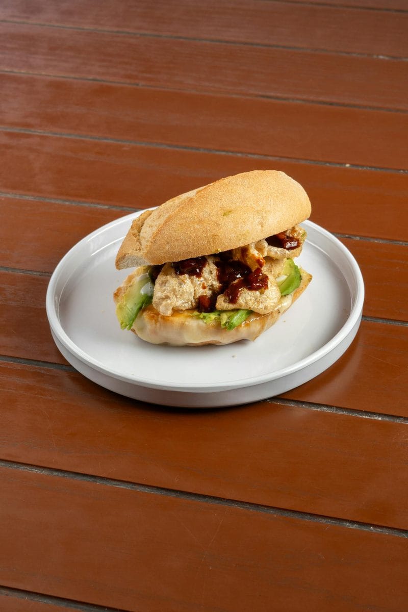 A Salvadoran chicken sandwich (pan con pollo) on a crusty roll