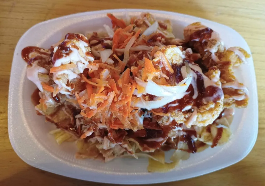Pollo chuco, Honduran fried chicken over plantain tajadas with slaw and sauces