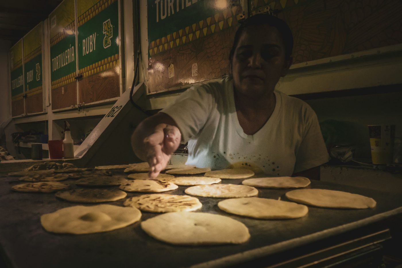 Cook making flour tortillas for baleadas at a San Pedro Sula tortillería