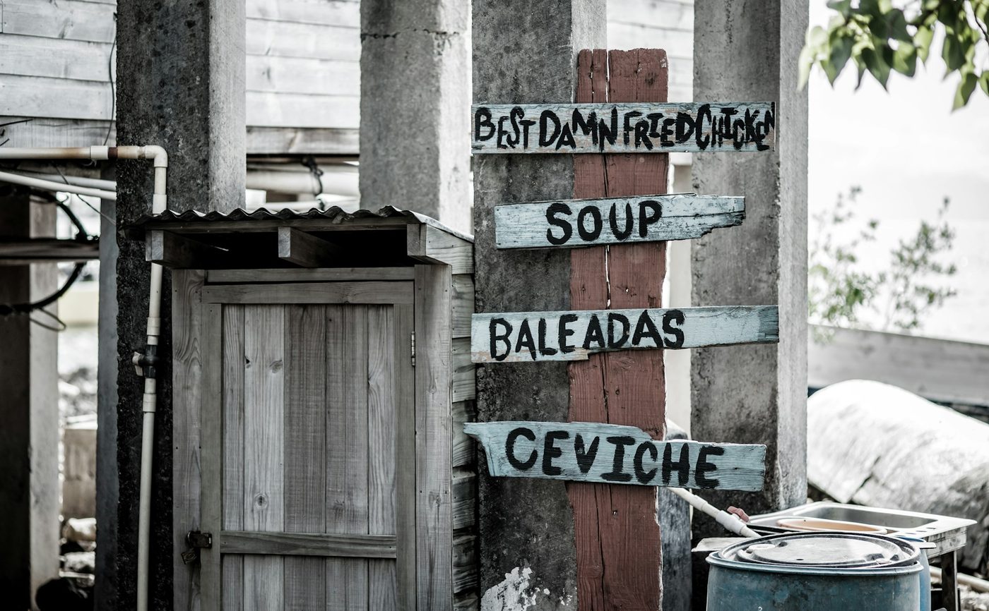 Hand-painted Utila street-food sign listing baleadas, fried chicken, soup, and ceviche