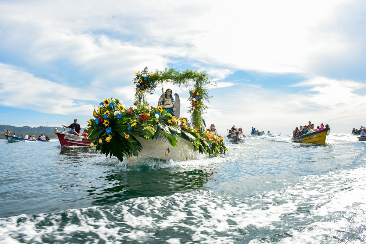 A flower-decked boat carries a saints image in a sea procession off El Salvadors Pacific coast