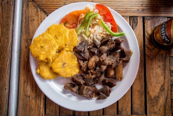 Haitian griot, fried pork cubes served with fried plantains and pikliz slaw