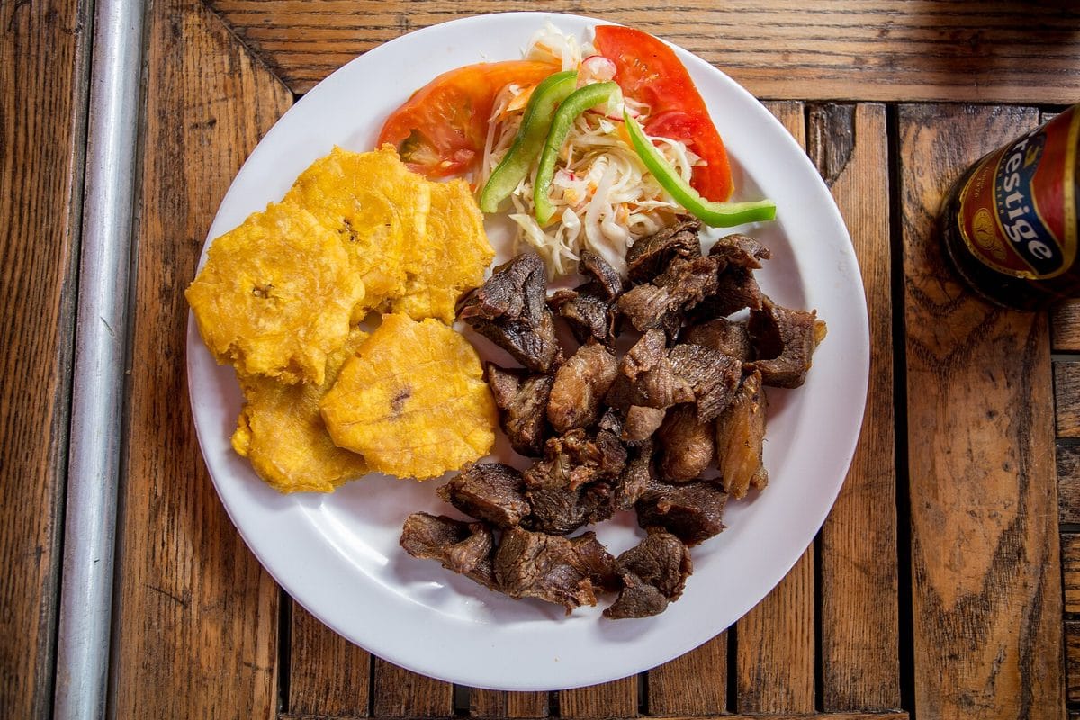 Haitian griot, fried pork cubes served with fried plantains and pikliz slaw
