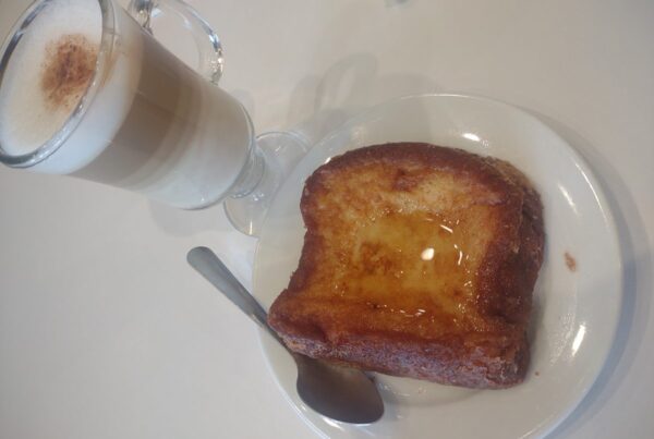 Salvadoran torrejas, a fried egg-bread slice glossy with syrup, served with a hot milky drink