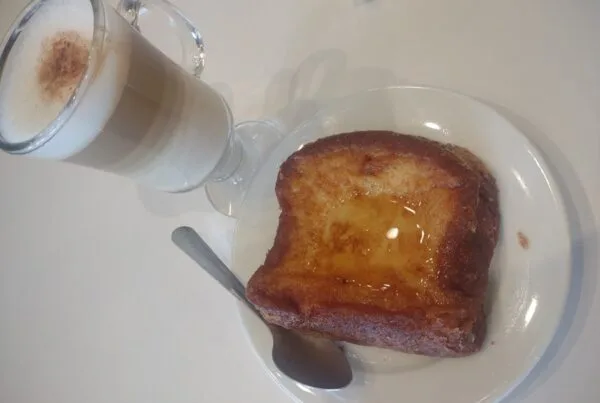 Salvadoran torrejas, a fried egg-bread slice glossy with syrup, served with a hot milky drink